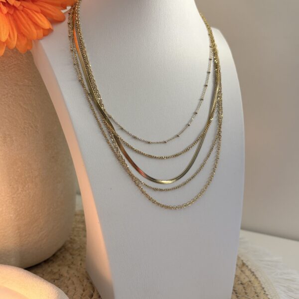 Collier multi-rangs doré posé sur un buste