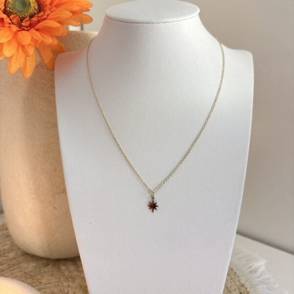 Collier Estelle, une chaine fine avec un petit pendentif en forme d'étoile posé sur un buste